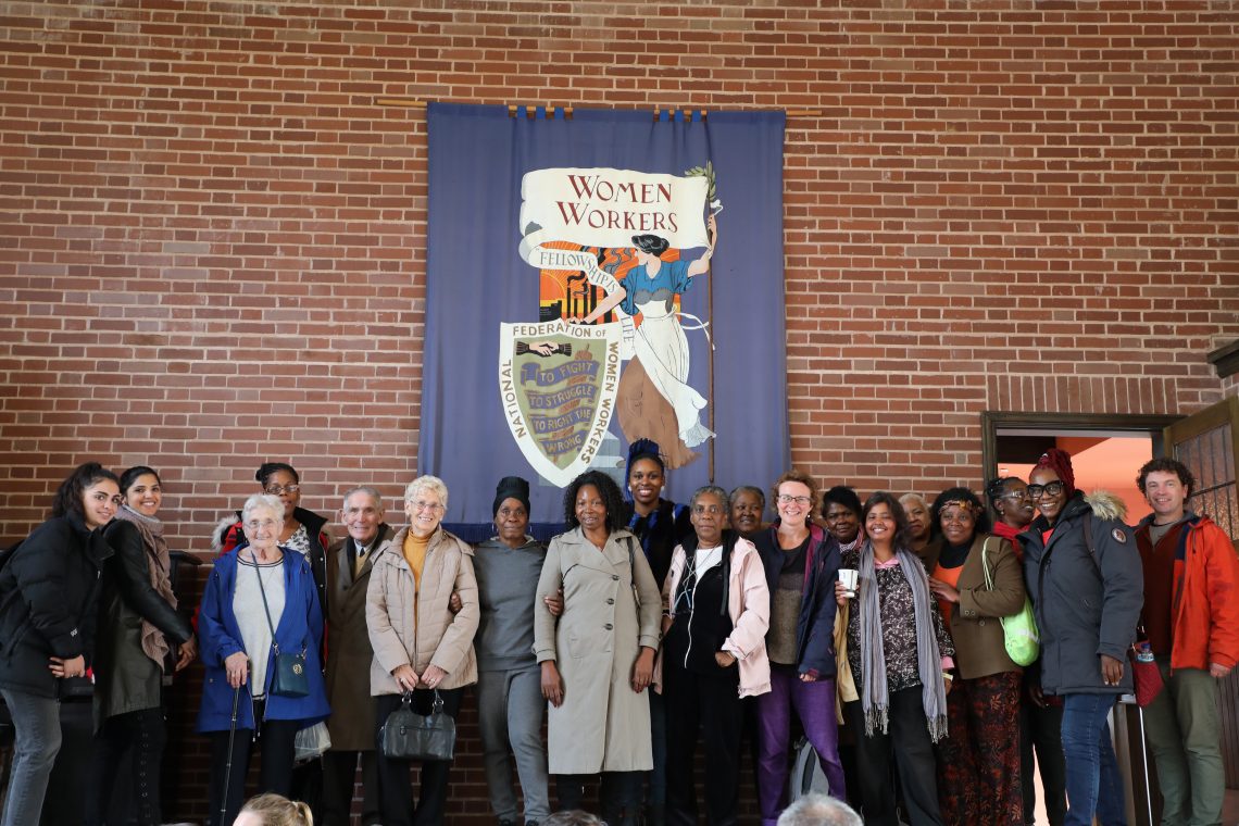 The group in front of a banner reading 'Women Workers'